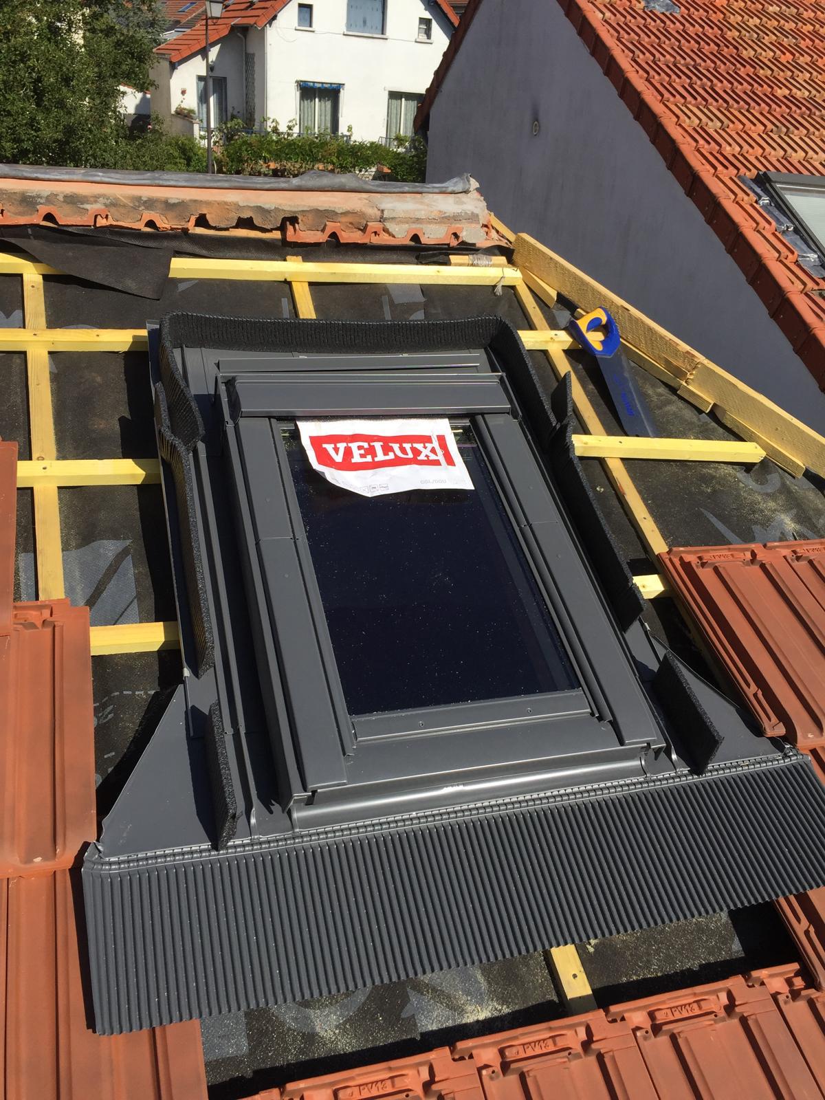 Pose d'une fenêtre de toit Velux sur une toiture en tuiles